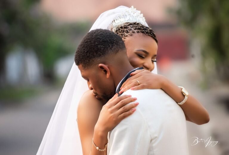 Les mariés s'enlacent, la mariée voilée sourit
