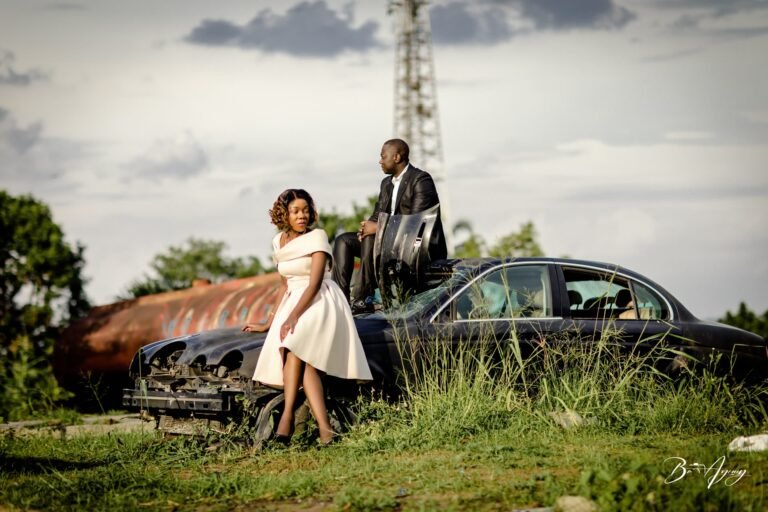 Couple posant sur une voiture ancienne lors d'une séance photo en extérieur