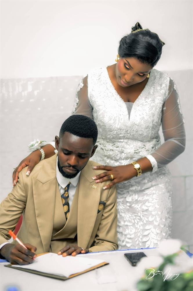 Le marié signe le registre à la mairie, la mariée à ses côtés, mariage civil à Kinshasa